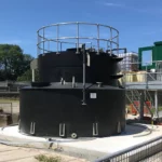 Black chemical tank outside with ladder access to the right