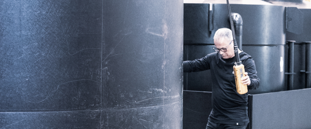 man near a plastic storage tank